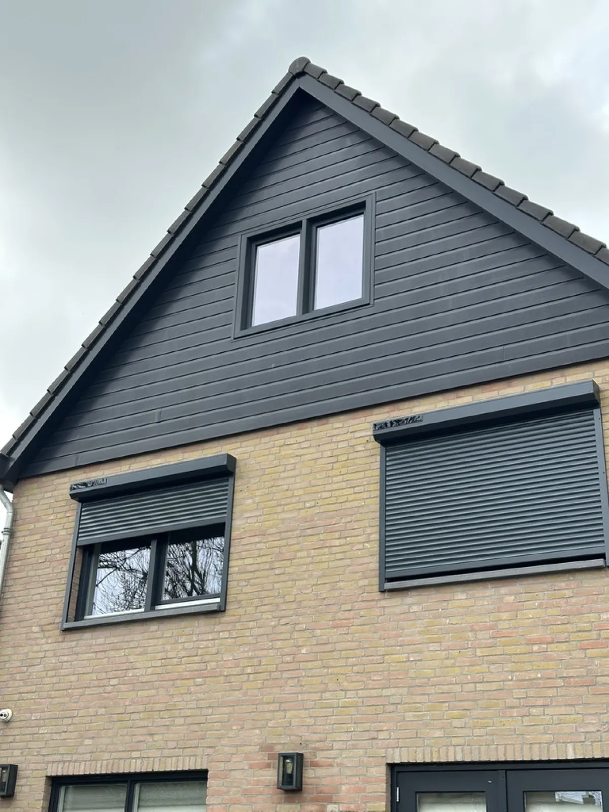 Modern nieuwbouwhuis met donker hout en rolluiken