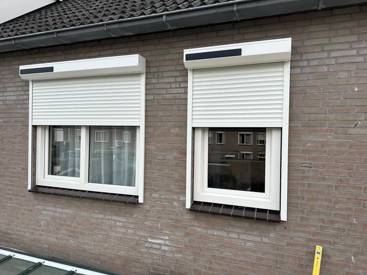 Twee witte rolluiken met solar-kast op een woning