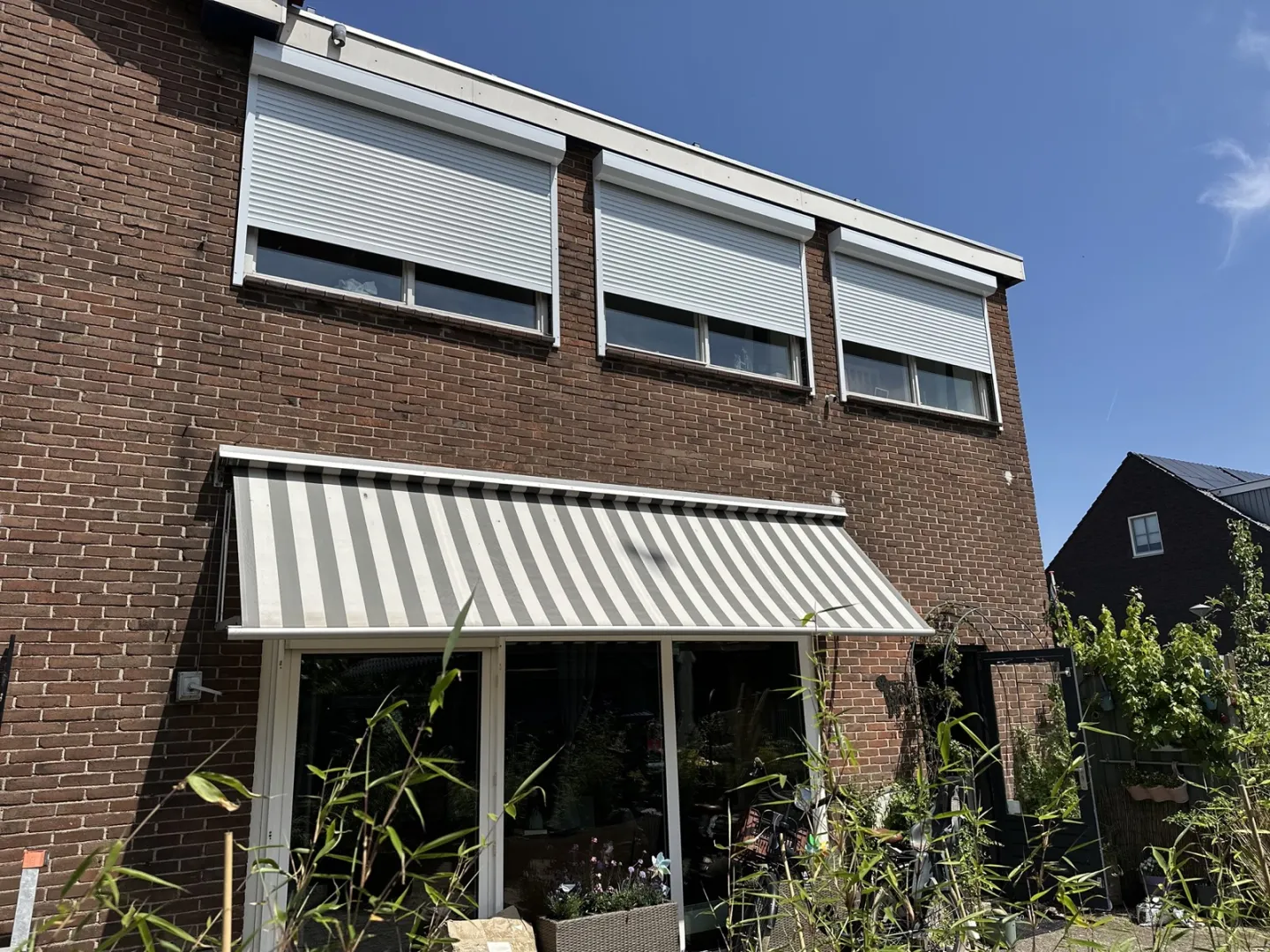 Uitvalschermen boven de ramen van een woonhuis